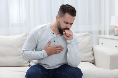 Photo of Sick man coughing at home. Cold symptoms