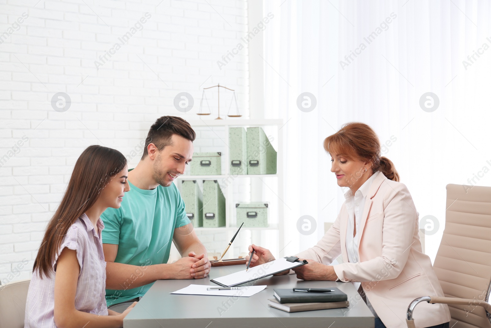 Photo of Lawyer having meeting with young couple in office