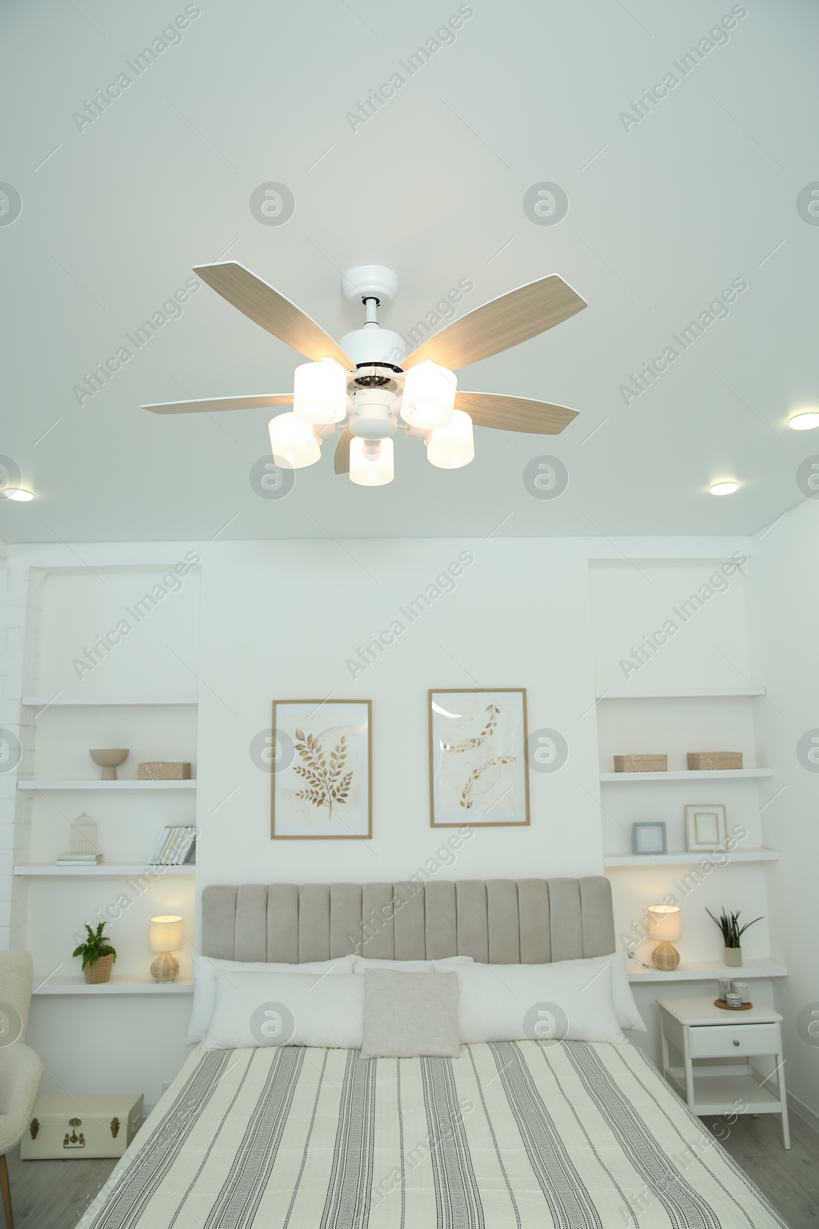 Photo of Ceiling fan, furniture and accessories in stylish bedroom