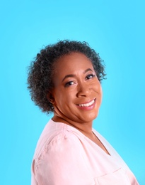 Photo of Portrait of happy African-American woman on light blue background