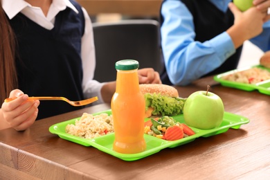 Photo of Children at table with healthy food in school canteen, closeup
