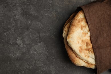 Photo of Delicious fresh pita bread and napkin on grey table, top view. Space for text