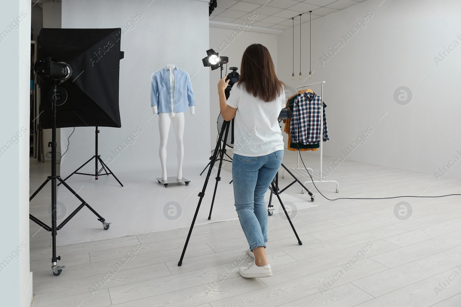 Photo of Professional photographer taking picture of ghost mannequin with modern clothes in photo studio