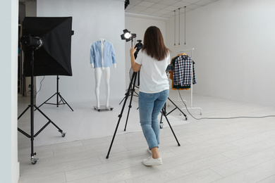 Photo of Professional photographer taking picture of ghost mannequin with modern clothes in photo studio