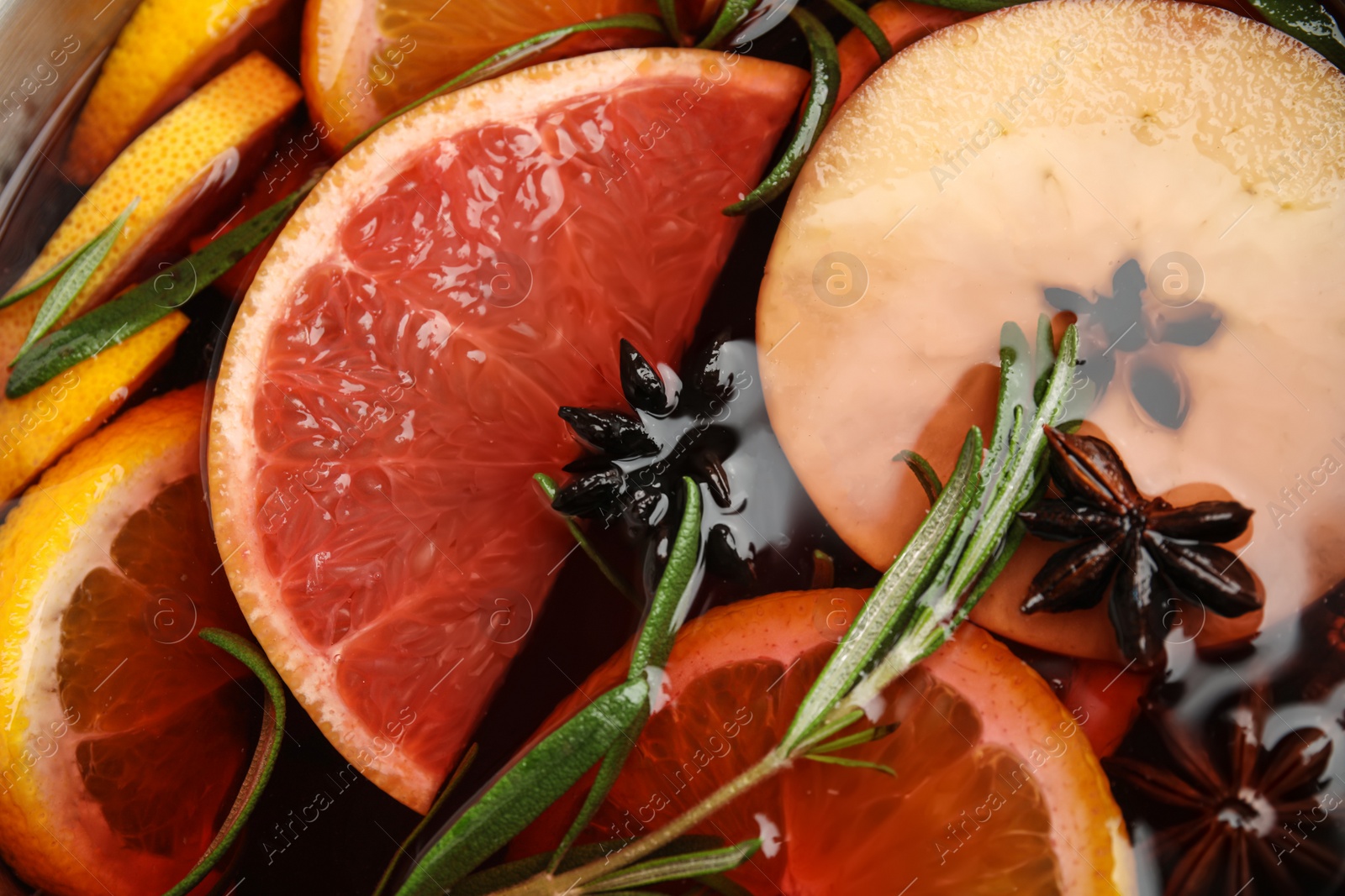 Photo of Tasty mulled wine with spices as background, closeup