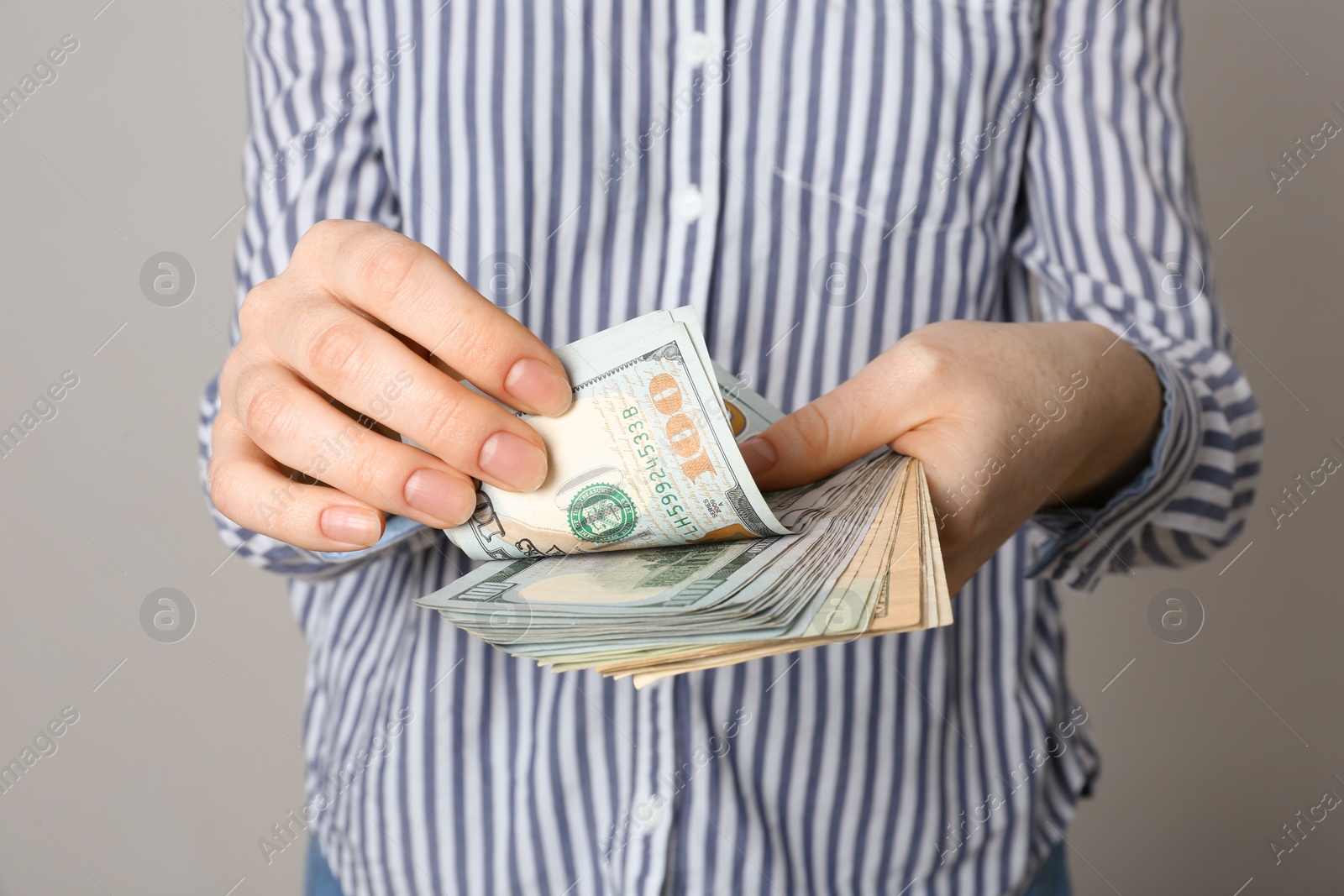 Photo of Woman with American money on grey background, closeup