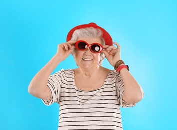 Photo of Portrait of cool grandmother on color background