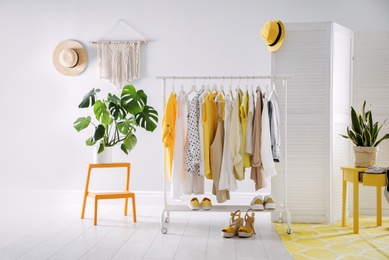 Photo of Dressing room interior with clothing rack and houseplants
