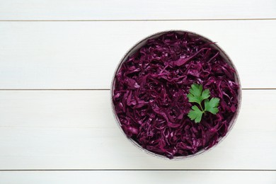 Photo of Tasty red cabbage sauerkraut with parsley on white wooden table, top view. Space for text