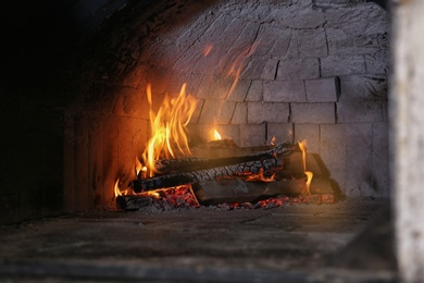 Oven with burning firewood in restaurant kitchen