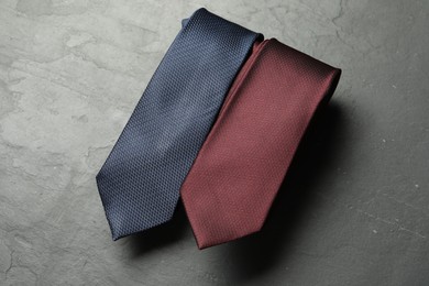 Photo of Two neckties on grey textured table, top view
