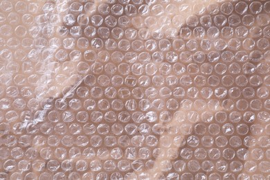 Photo of Transparent bubble wrap on kraft paper, top view