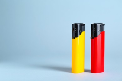 Photo of Stylish small pocket lighters on white background, space for text
