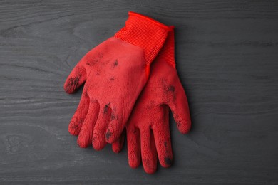 Photo of Pair of red gardening gloves on grey wooden table, top view