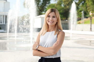 Portrait of beautiful blonde woman outdoors on sunny day