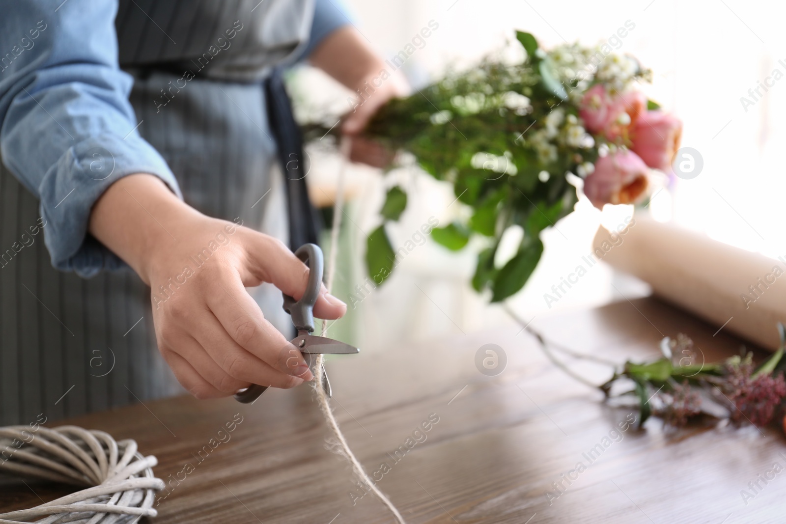 Photo of Female florist creating beautiful bouquet at table