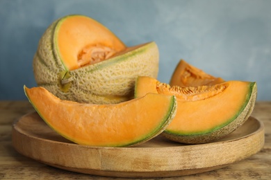 Photo of Tasty fresh cut melons on wooden tray, closeup