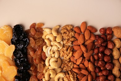 Photo of Mix of delicious dried nuts and fruits on beige background, flat lay