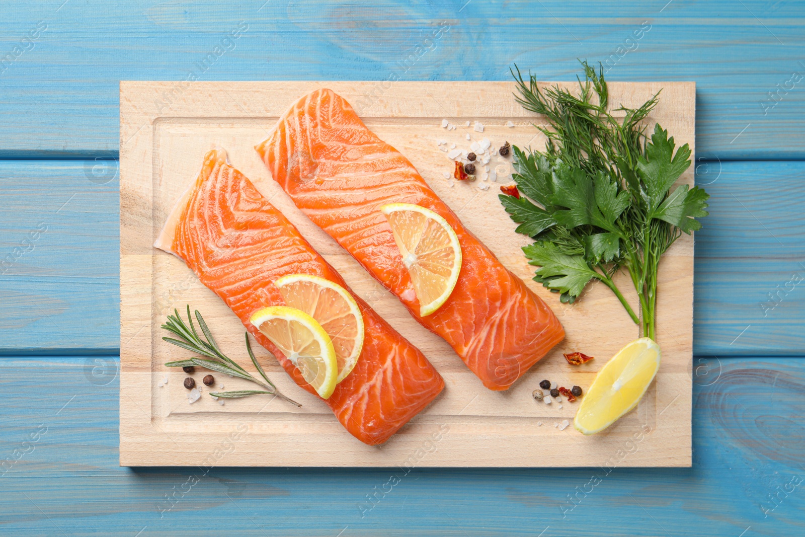 Photo of Fresh salmon and ingredients for marinade on light blue wooden table, top view