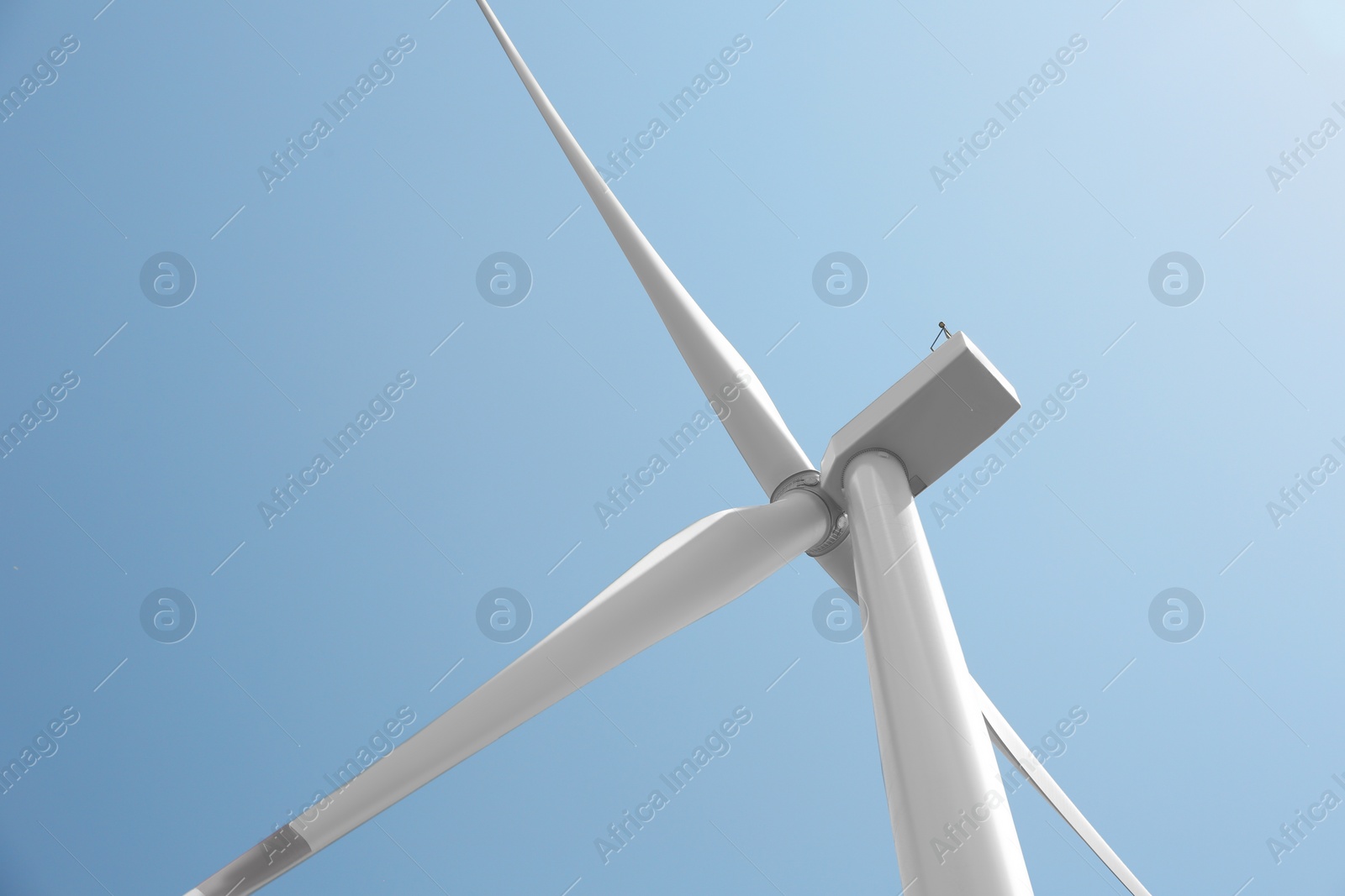 Photo of Modern wind turbine against blue sky, low angle view. Energy efficiency