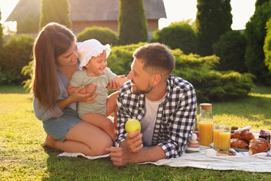 Happy family having picnic in garden on sunny day