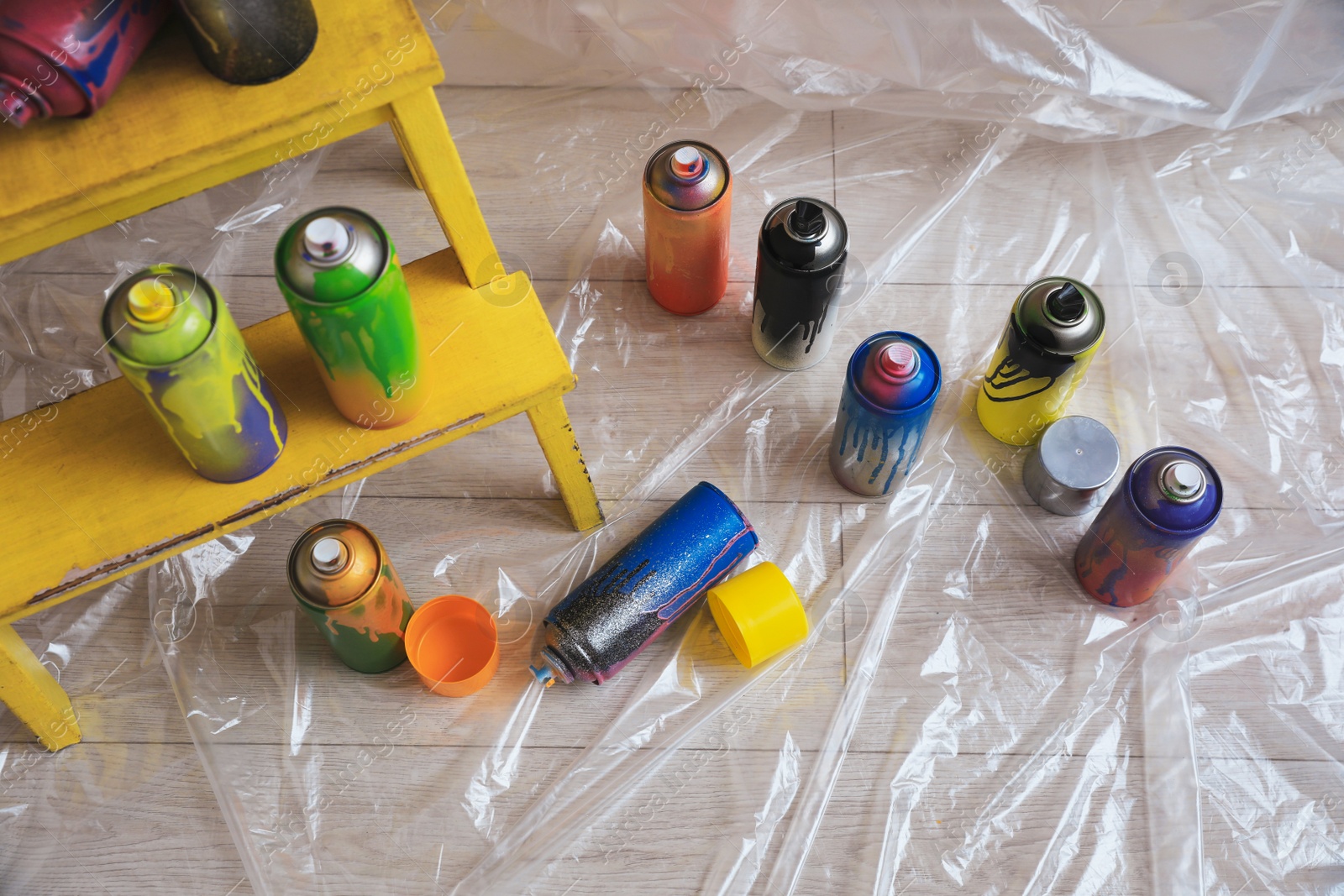 Photo of Used cans of spray paints indoors, above view. Graffiti supplies