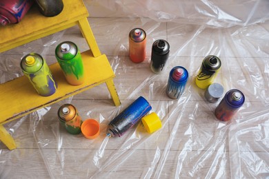 Photo of Used cans of spray paints indoors, above view. Graffiti supplies