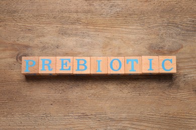 Wooden cubes with word Prebiotic on table, flat lay