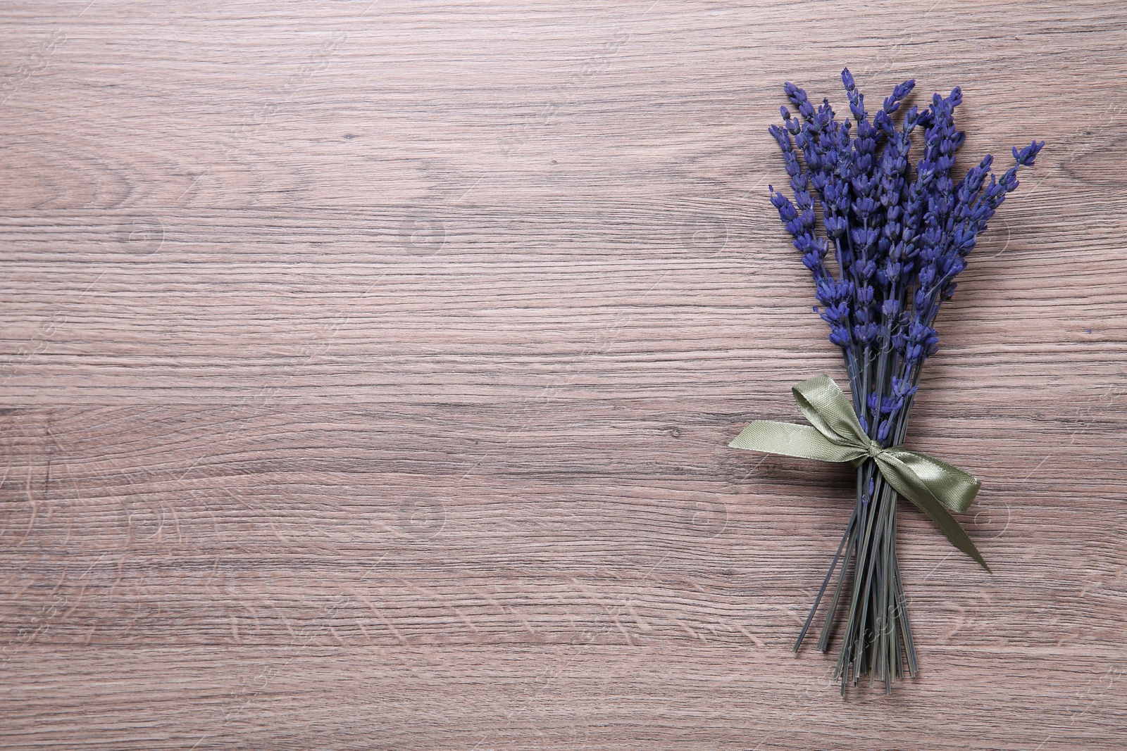 Photo of Bouquet of beautiful preserved lavender flowers on wooden table, top view. Space for text