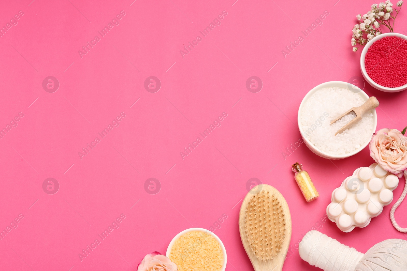 Photo of Sea salt and different spa products on pink background, flat lay. Space for text