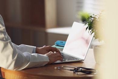 Photo of Professional doctor working on laptop in office, closeup