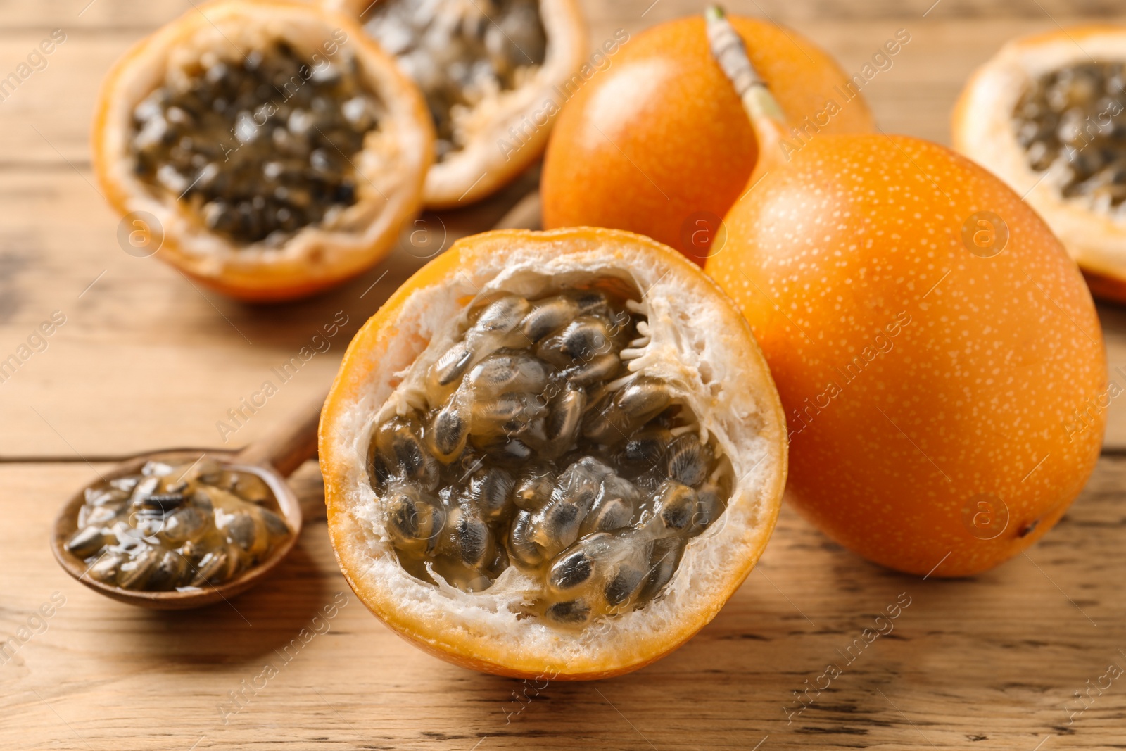 Photo of Delicious ripe granadillas on wooden table, closeup