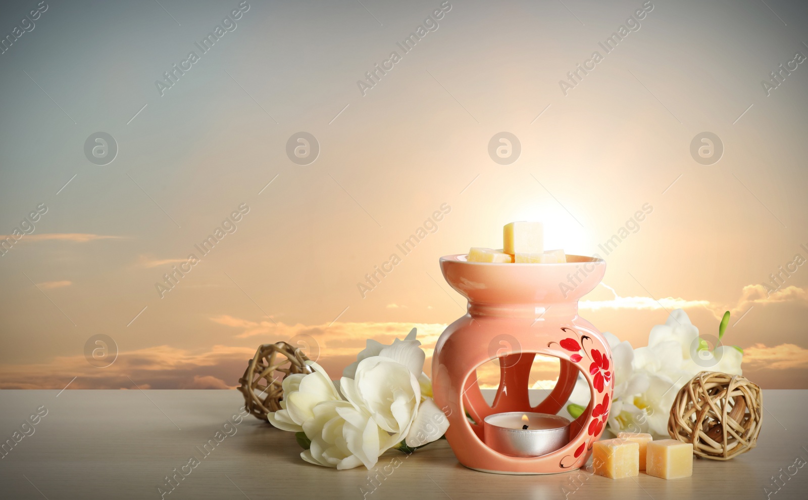 Image of Composition with aroma lamp on wooden table outdoors at sunset, space for text