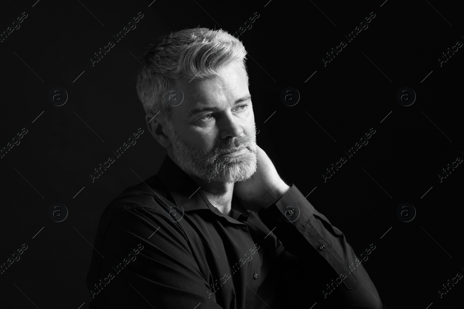 Photo of Portrait of handsome man on dark background. Black and white effect