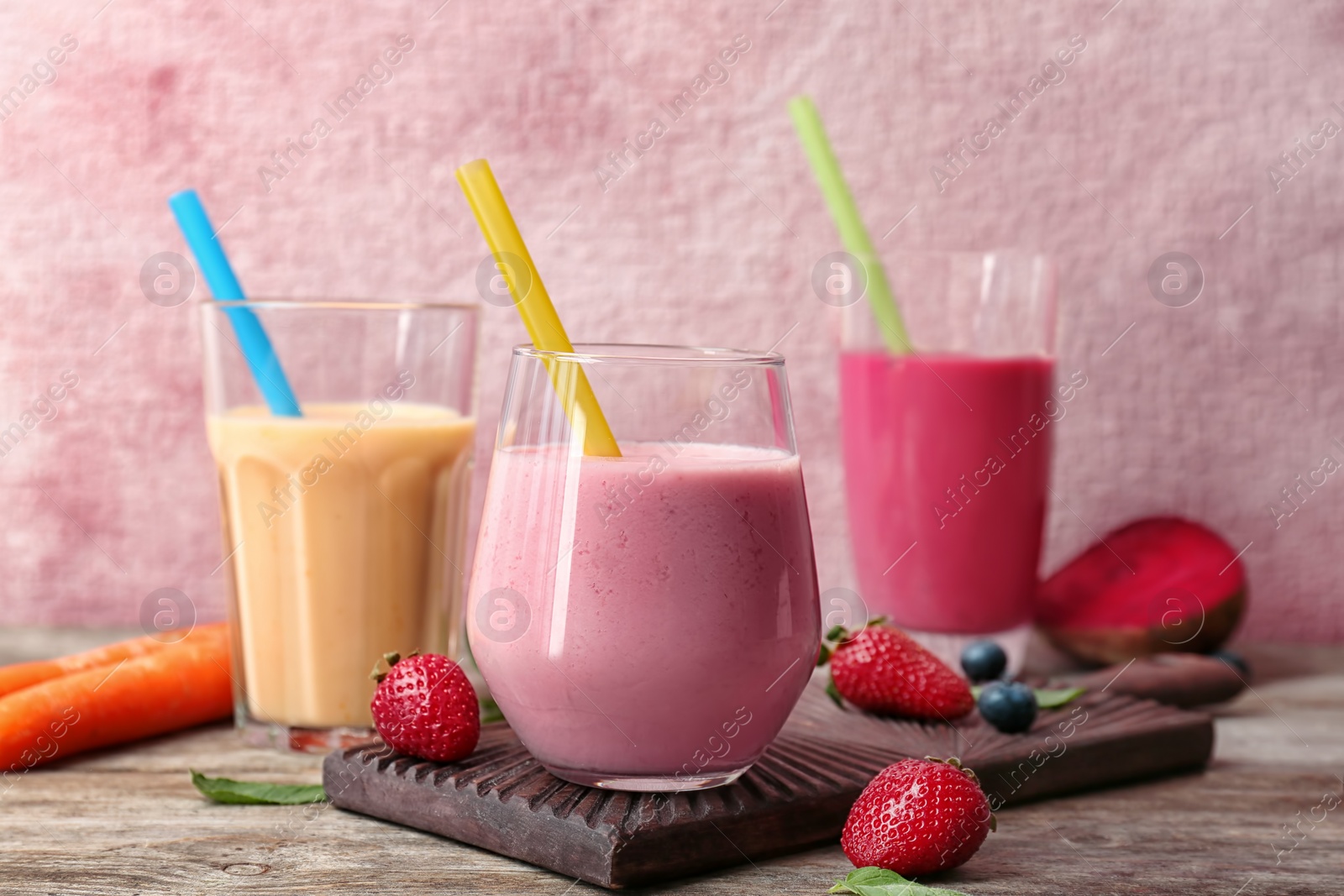 Photo of Glasses with healthy detox smoothies and ingredients on table