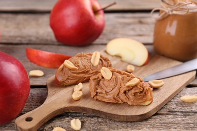 Photo of Fresh apples with peanut butter on wooden table