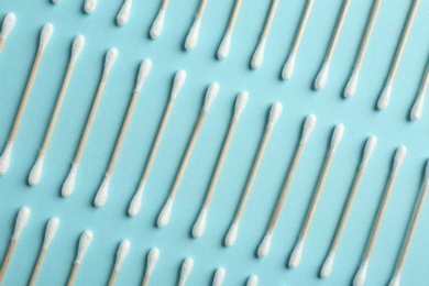 Photo of Flat lay composition with cotton swabs on color background