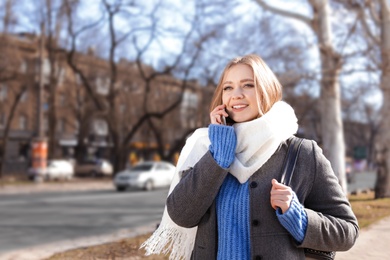 Portrait of happy young woman talking on phone outdoors