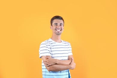 Photo of Portrait of handsome young man smiling on color background