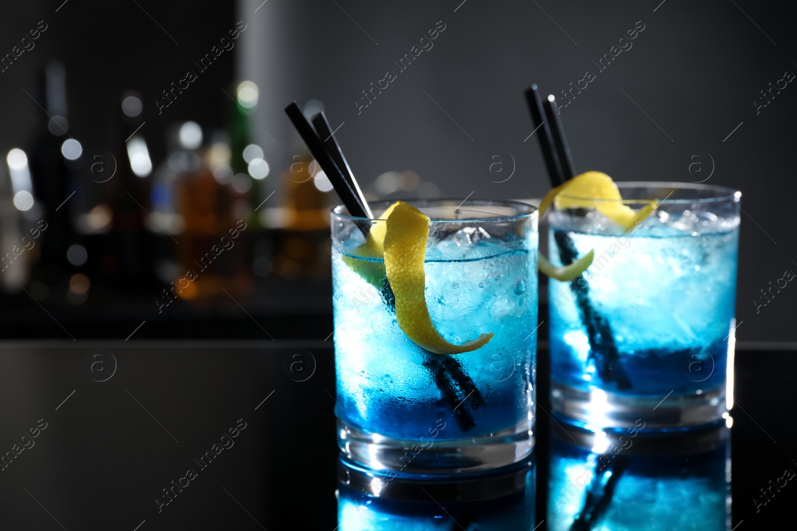 Photo of Glasses of fresh alcoholic cocktails on bar counter, space for text