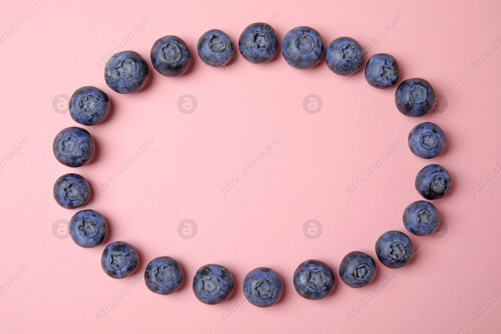 Photo of Frame of ripe blueberries on pink background, flat lay with space for text