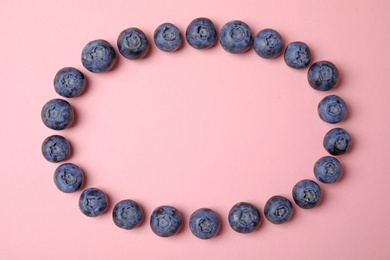 Frame of ripe blueberries on pink background, flat lay with space for text