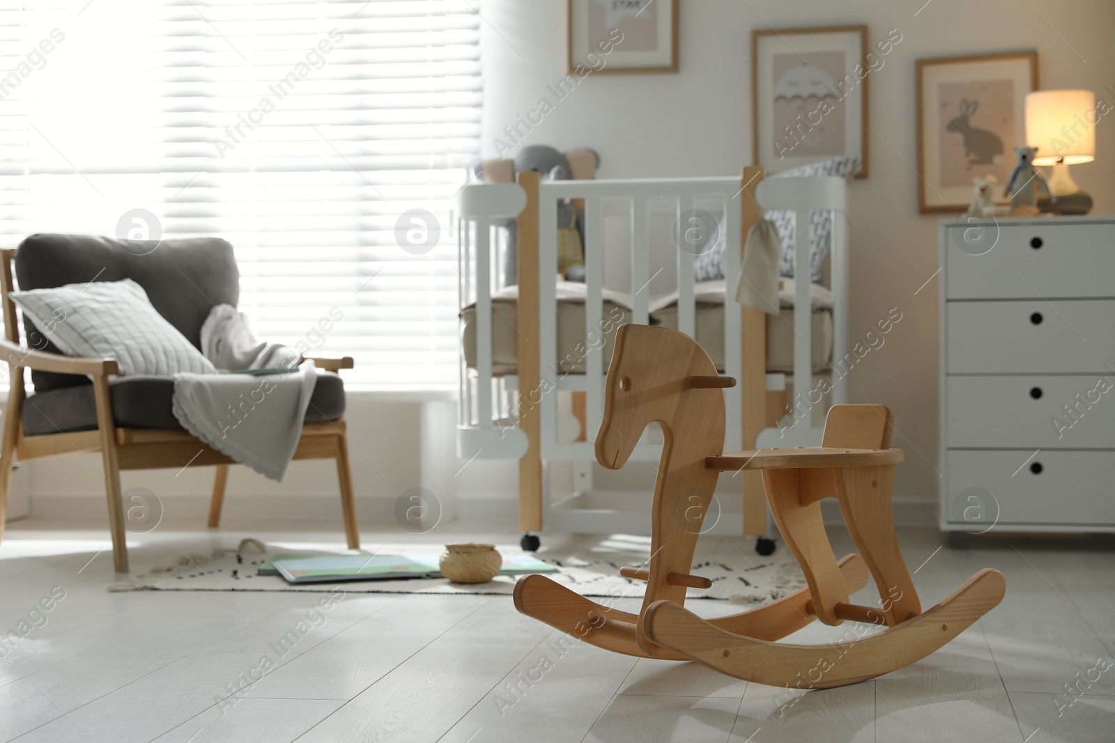 Photo of Wooden rocking horse in baby room interior. Idea for design