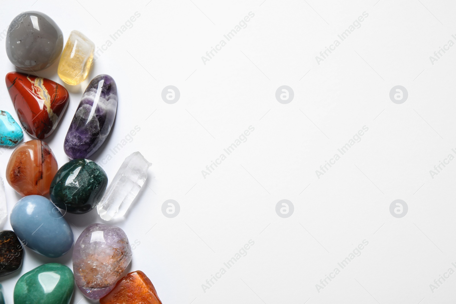 Photo of Different beautiful gemstones on white background, top view