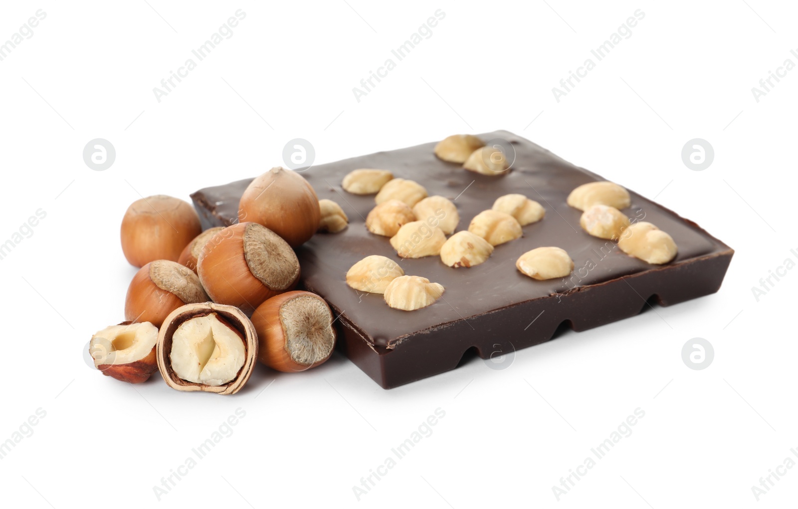 Photo of Delicious chocolate bar and hazelnuts on white background