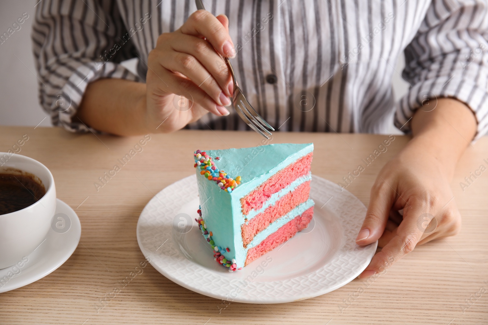 Photo of Woman eating fresh delicious birthday cake at table, closeup