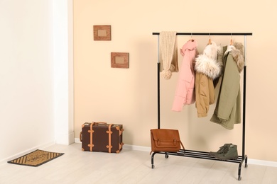 Stylish hallway interior with clothes on hanger stand