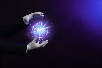 Image of Magician performing magic trick on color background, closeup