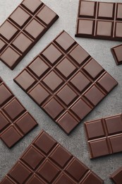 Delicious dark chocolate on grey table, flat lay