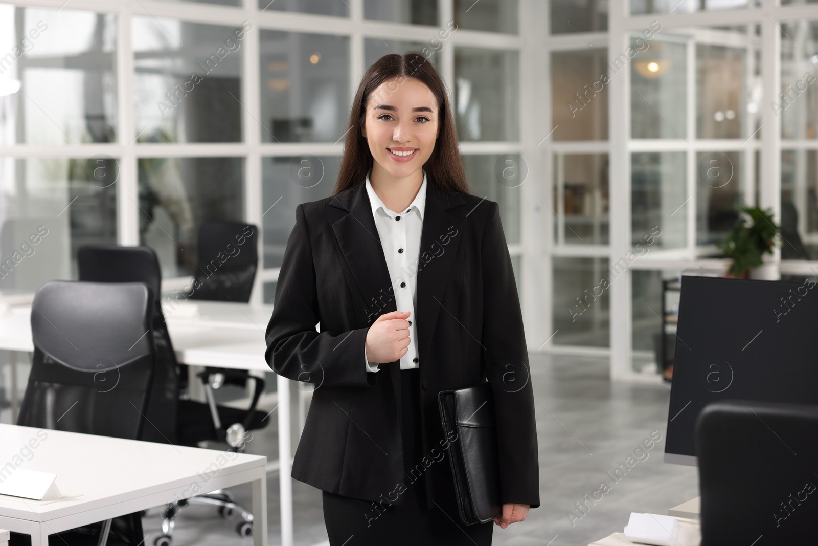 Photo of Happy real estate agent with leather portfolio in office